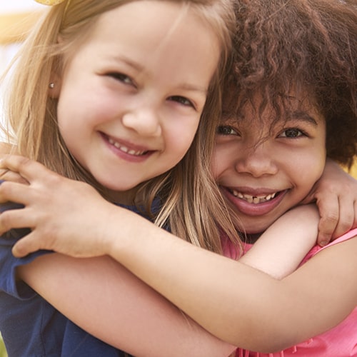 Two girls hugging while smiling