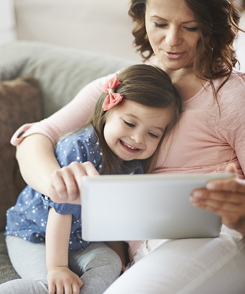 A mother and daughter sit on the couch while reviewing Northtown Kids Dental & Orthodontics insurance options
